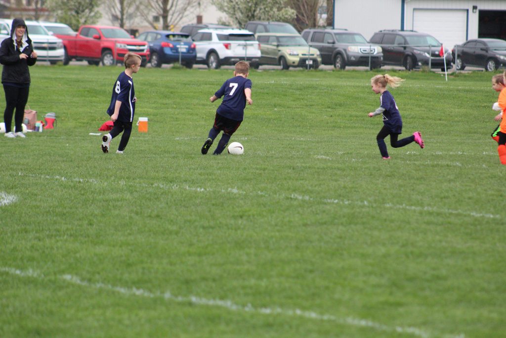 child kicking soccer ball